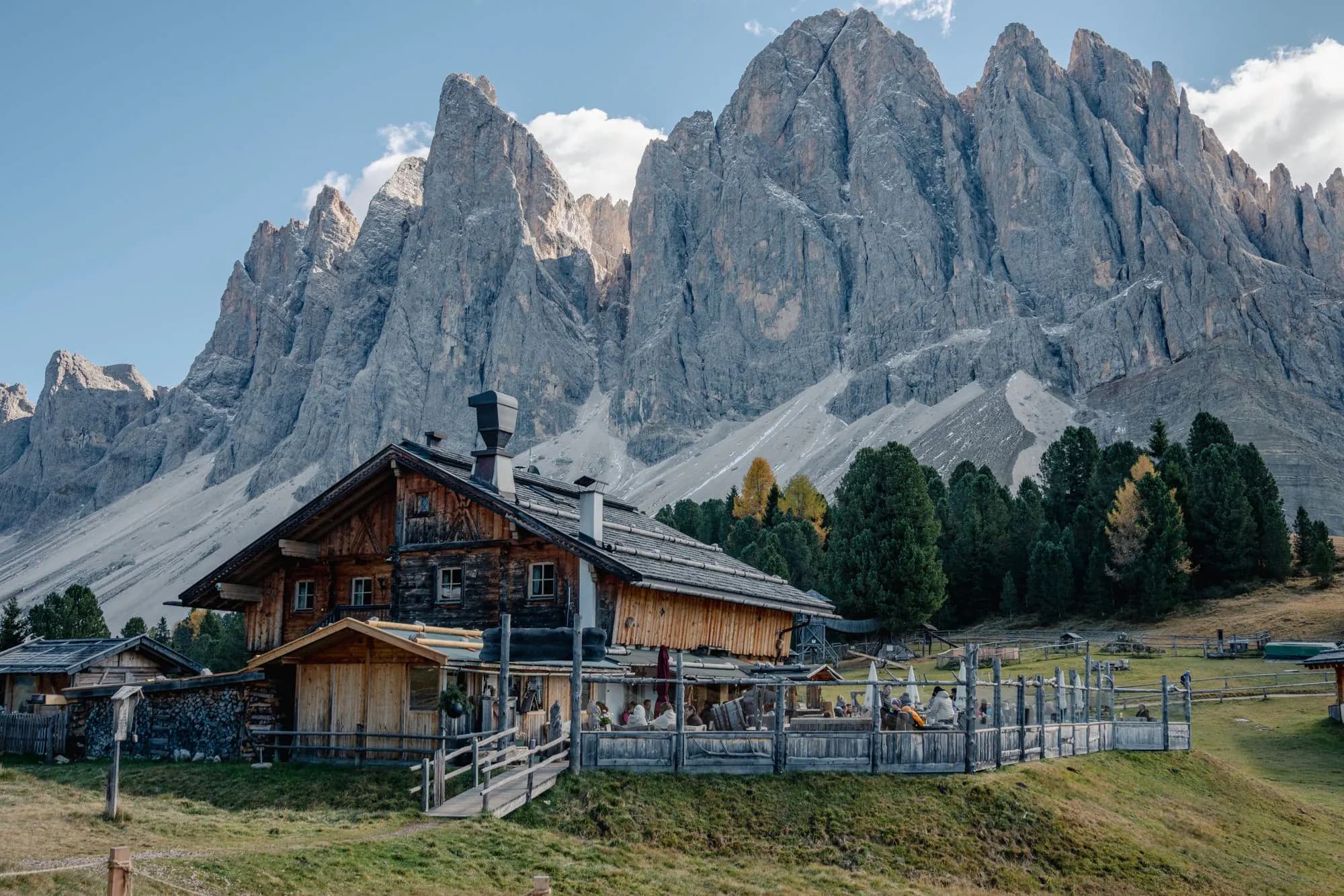 A mountain hut below steep Dolomites rock towers